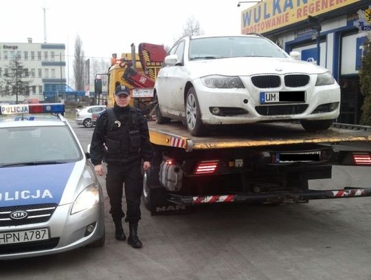 Białe bmw zaparkowane przy lesie 