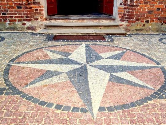 Kamienna Róża Wiatrów przed wejściem do kościoła Św. Mikołaja w Gniewie