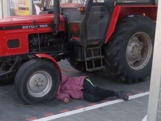 Leżał na parkingu pod traktorem