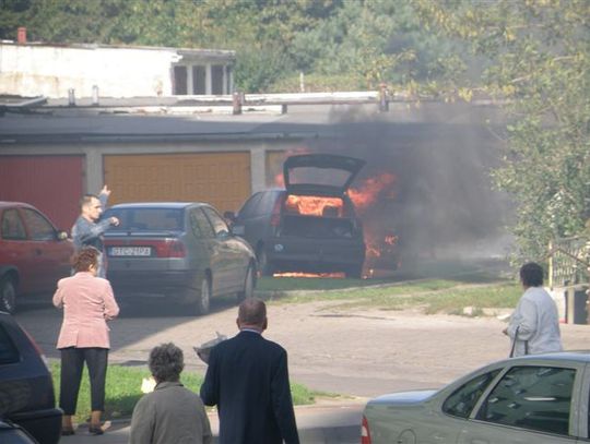 Płonące auto na parkingu