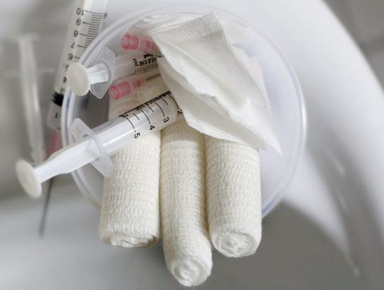Zakrwawione chusty chirurgiczne, zużyte igły, strzykawki na składowisku 